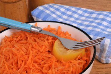 Izgara havuç, çatal ve limon dilimli tabakta servis edilir.