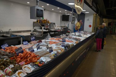 Nimes pazarındaki balıkçı tezgahının önündeki müşteriler.