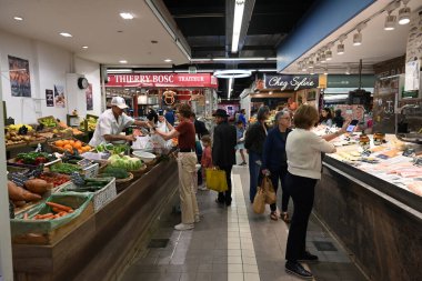 Bir balıkçının tezgahının önündeki müşteriler ve Nimes pazarındaki manavlar.