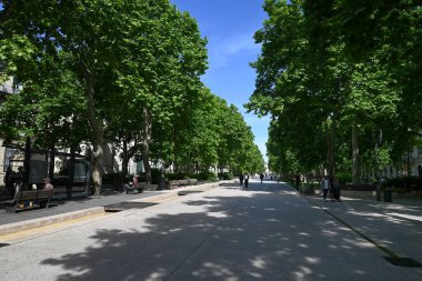 Nimes 'teki Bulvar Feucheres' in gölgesinde yürü