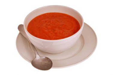 Bir kase ev yapımı gazpacho ve beyaz arka planda izole edilmiş kaşık yakın plan.