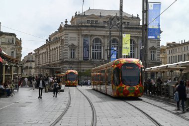 Montpellier Comedie Square istasyonunda arka planda opera olan toplu taşıma tramvayları
