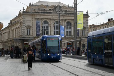 Montpellier Comedie Square istasyonunda arka planda opera olan toplu taşıma tramvayları