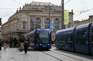 Montpellier Comedie Square istasyonunda arka planda opera olan toplu taşıma tramvayları