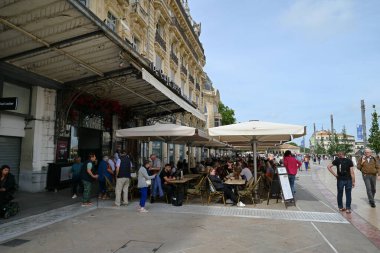Montpellier 'deki Comedie Meydanı' nda müşterilerle kafe terası.