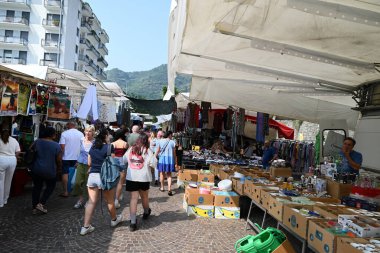 Turistler ve müşteriler Como pazarındaki tezgahlarda dolaşıyorlar.