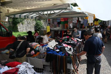 Müşteriler Como 'daki bir markette kıyafet ve kemerleri inceliyor.