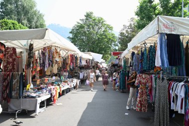 Turistler ve müşteriler Como pazarındaki tezgahlarda dolaşıyorlar.