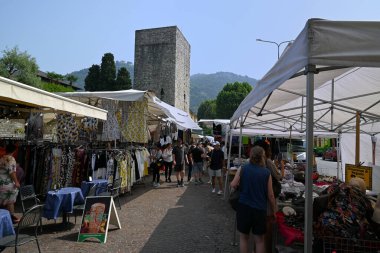 Turistler ve müşteriler Como pazarındaki tezgahlarda dolaşıyorlar.