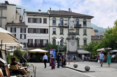 Como 'daki Piazza Alessandro Volta. Fizikçi heykeli ve restoran teraslarıyla birlikte.