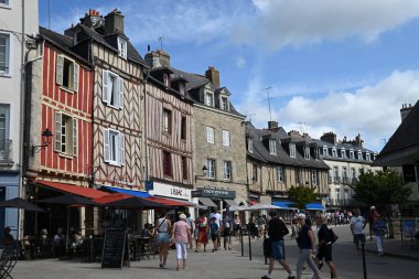 Lucien Laroche Meydanı 'nda turistlerle dolu kafe terasları ve dükkanlar.
