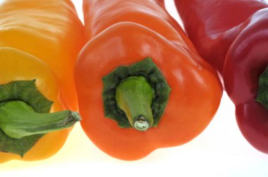 Arka planda farklı renklerde tatlı biberler.