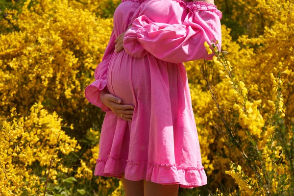 Mujer Embarazada Vestido Rosa Toma Mano Vientre Sobre Fondo Amarillo — Foto de Stock