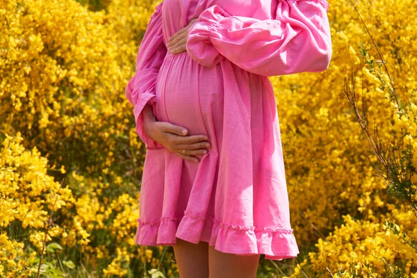 Mujer Embarazada Vestido Rosa Toma Mano Vientre Sobre Fondo Amarillo — Foto de Stock
