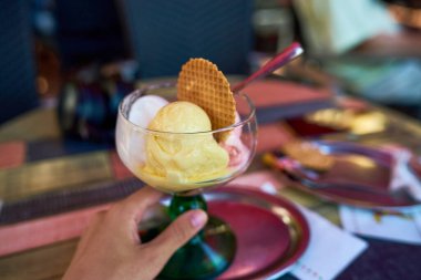 Lezzetli bir dondurma bardağını kapat. Restoranda Limonlu Limonlu Vanilyalı Dondurma ve Tatlı Bisküvi Krepleri 'nin yakın görüntüsü. Kırsal Ahşap Masa' da Cam Tabak 'ta servis ediliyor.                                           