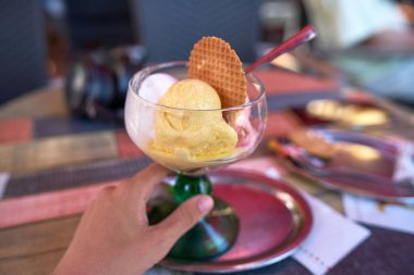 Lezzetli bir dondurma bardağını kapat. Restoranda Limonlu Limonlu Vanilyalı Dondurma ve Tatlı Bisküvi Krepleri 'nin yakın görüntüsü. Kırsal Ahşap Masa' da Cam Tabak 'ta servis ediliyor.                                           