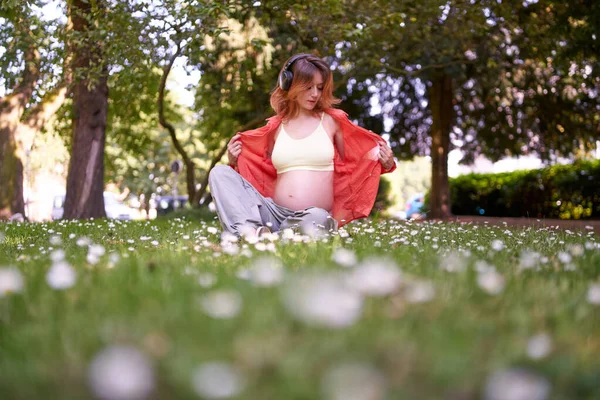 Mujer Embarazada Usa Auriculares Para Escuchar Música Desde Teléfono Inteligente — Foto de Stock