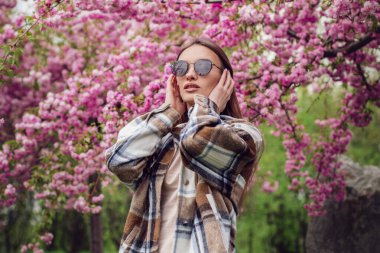 Sakura parkında çekici, şık bir kadının portresi.