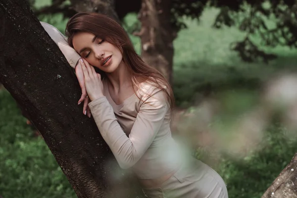 迷人的年轻女子在绿树成荫的森林里嬉笑的画像 — 图库照片