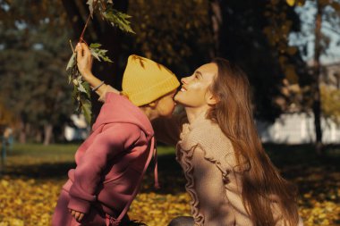 Mutlu anne ve küçük kızı sonbaharda dışarıda.