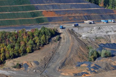Büyük kamyonlar otoyol inşaatı için toprak ve taş kazıyor