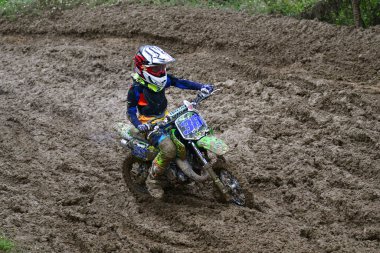 Orman, Makedonya, 14 Mayıs 2023. Yağmurlu havada ve çamurlu pistte, motosiklet yarışçıları zor koşullarda çeşitli kategorilerde yarıştılar..