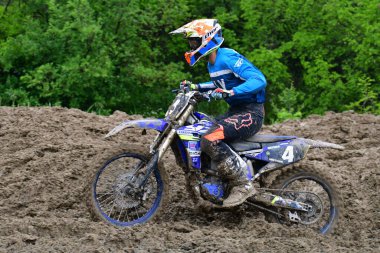 Orman, Makedonya, 14 Mayıs 2023. Yağmurlu havada ve çamurlu pistte, motosiklet yarışçıları zor koşullarda çeşitli kategorilerde yarıştılar..