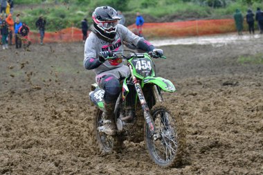 Orman, Makedonya, 14 Mayıs 2023. Yağmurlu havada ve çamurlu pistte, motosiklet yarışçıları zor koşullarda çeşitli kategorilerde yarıştılar..