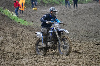 Orman, Makedonya, 14 Mayıs 2023. Yağmurlu havada ve çamurlu pistte, motosiklet yarışçıları zor koşullarda çeşitli kategorilerde yarıştılar..