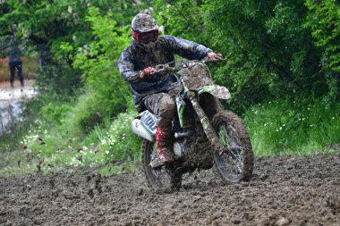 Orman, Makedonya, 14 Mayıs 2023. Yağmurlu havada ve çamurlu pistte, motosiklet yarışçıları zor koşullarda çeşitli kategorilerde yarıştılar..