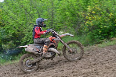 Orman, Makedonya, 14 Mayıs 2023. Yağmurlu havada ve çamurlu pistte, motosiklet yarışçıları zor koşullarda çeşitli kategorilerde yarıştılar..