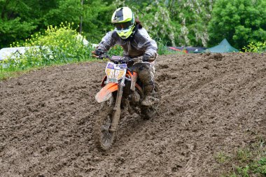 Orman, Makedonya, 14 Mayıs 2023. Yağmurlu havada ve çamurlu pistte, motosiklet yarışçıları zor koşullarda çeşitli kategorilerde yarıştılar..