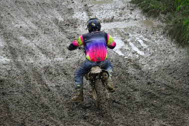 Orman, Makedonya, 14 Mayıs 2023. Yağmurlu havada ve çamurlu pistte, motosiklet yarışçıları zor koşullarda çeşitli kategorilerde yarıştılar..