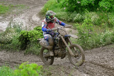 Orman, Makedonya, 14 Mayıs 2023. Yağmurlu havada ve çamurlu pistte, motosiklet yarışçıları zor koşullarda çeşitli kategorilerde yarıştılar..