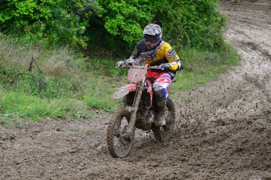 Orman, Makedonya, 14 Mayıs 2023. Yağmurlu havada ve çamurlu pistte, motosiklet yarışçıları zor koşullarda çeşitli kategorilerde yarıştılar..