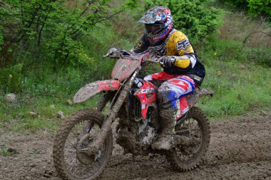 Orman, Makedonya, 14 Mayıs 2023. Yağmurlu havada ve çamurlu pistte, motosiklet yarışçıları zor koşullarda çeşitli kategorilerde yarıştılar..