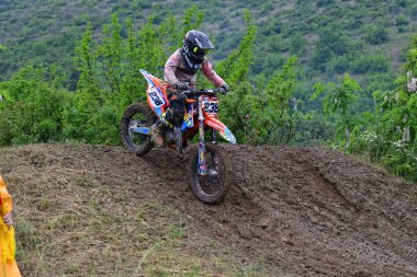 Orman, Makedonya, 14 Mayıs 2023. Yağmurlu havada ve çamurlu pistte, motosiklet yarışçıları zor koşullarda çeşitli kategorilerde yarıştılar..