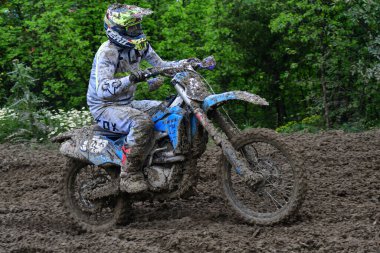 Orman, Makedonya, 14 Mayıs 2023. Yağmurlu havada ve çamurlu pistte, motosiklet yarışçıları zor koşullarda çeşitli kategorilerde yarıştılar..