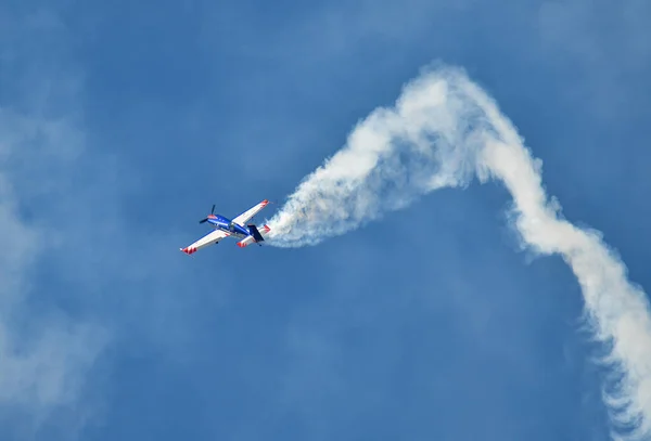 Stock image September 16, 2023, Skopje,  Macedonia, Stenkovec Sports Airport, Airshow was held. The French acrobatic plane Extra 330SC with a trail of smoke he performed miracles over the heads of spectators.