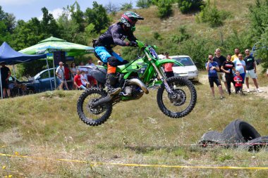 25 Haziran 2023, Veles, Makedonya. Enduro ekstrem moto yarışında sürücüler zorlu bir arazide lastiklerin üzerinden atlayarak ve dağ yollarında 40 kilometrelik bir sürüş yaparak yarıştılar..