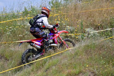 25 Haziran 2023, Veles, Makedonya. Enduro ekstrem moto yarışında sürücüler zorlu bir arazide lastiklerin üzerinden atlayarak ve dağ yollarında 40 kilometrelik bir sürüş yaparak yarıştılar..