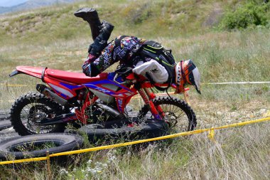 25 Haziran 2023, Veles, Makedonya. Enduro ekstrem moto yarışında sürücüler zorlu bir arazide lastiklerin üzerinden atlayarak ve dağ yollarında 40 kilometrelik bir sürüş yaparak yarıştılar..