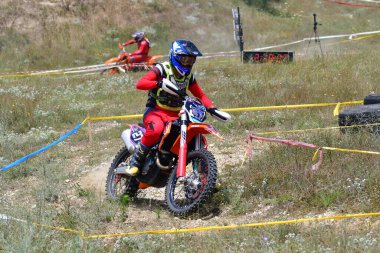 25 Haziran 2023, Veles, Makedonya. Enduro ekstrem moto yarışında sürücüler zorlu bir arazide lastiklerin üzerinden atlayarak ve dağ yollarında 40 kilometrelik bir sürüş yaparak yarıştılar..
