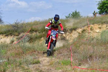 25 Haziran 2023, Veles, Makedonya. Enduro ekstrem moto yarışında sürücüler zorlu bir arazide lastiklerin üzerinden atlayarak ve dağ yollarında 40 kilometrelik bir sürüş yaparak yarıştılar..