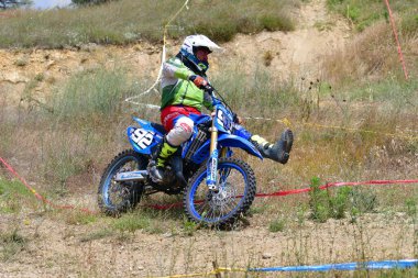 25 Haziran 2023, Veles, Makedonya. Enduro ekstrem moto yarışında sürücüler zorlu bir arazide lastiklerin üzerinden atlayarak ve dağ yollarında 40 kilometrelik bir sürüş yaparak yarıştılar..