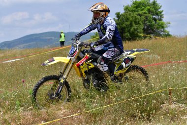 25 Haziran 2023, Veles, Makedonya. Enduro ekstrem moto yarışında sürücüler zorlu bir arazide lastiklerin üzerinden atlayarak ve dağ yollarında 40 kilometrelik bir sürüş yaparak yarıştılar..