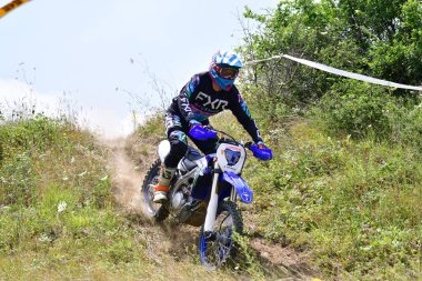 25 Haziran 2023, Veles, Makedonya. Enduro ekstrem moto yarışında sürücüler zorlu bir arazide lastiklerin üzerinden atlayarak ve dağ yollarında 40 kilometrelik bir sürüş yaparak yarıştılar..