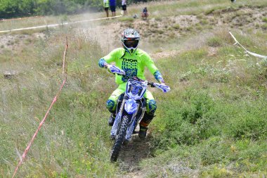 25 Haziran 2023, Veles, Makedonya. Enduro ekstrem moto yarışında sürücüler zorlu bir arazide lastiklerin üzerinden atlayarak ve dağ yollarında 40 kilometrelik bir sürüş yaparak yarıştılar..