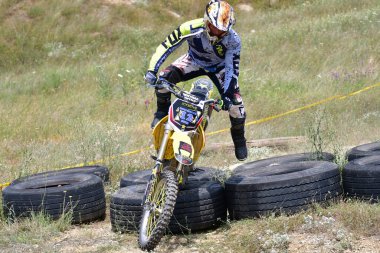 25 Haziran 2023, Veles, Makedonya. Enduro ekstrem moto yarışında sürücüler zorlu bir arazide lastiklerin üzerinden atlayarak ve dağ yollarında 40 kilometrelik bir sürüş yaparak yarıştılar..