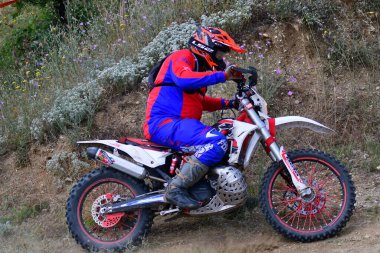 25 Haziran 2023, Veles, Makedonya. Enduro ekstrem moto yarışında sürücüler zorlu bir arazide lastiklerin üzerinden atlayarak ve dağ yollarında 40 kilometrelik bir sürüş yaparak yarıştılar..
